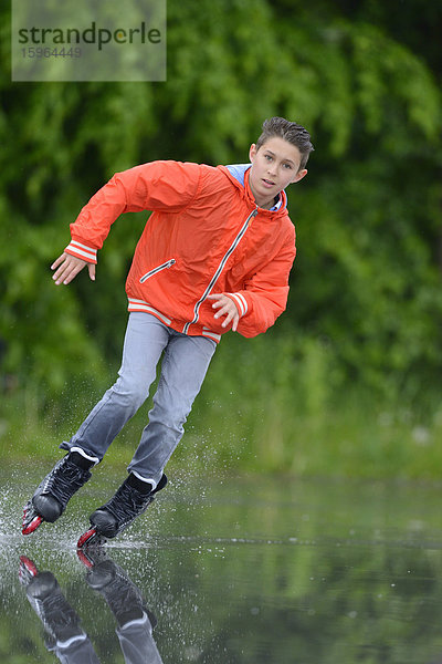 Junge mit Inline-Skates an einem regnerischen Tag