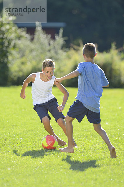 Zwei Teenager spielen Fußball auf der Wiese  Oberpfalz  Bayern  Deutschland  Europa