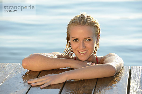 Junge blonde Frau an einem Steg an einem See  Steiermark  Österreich
