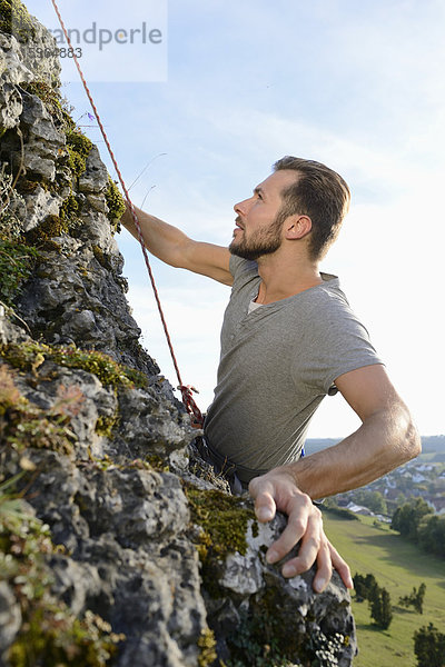 Mann klettert auf einem Felsen