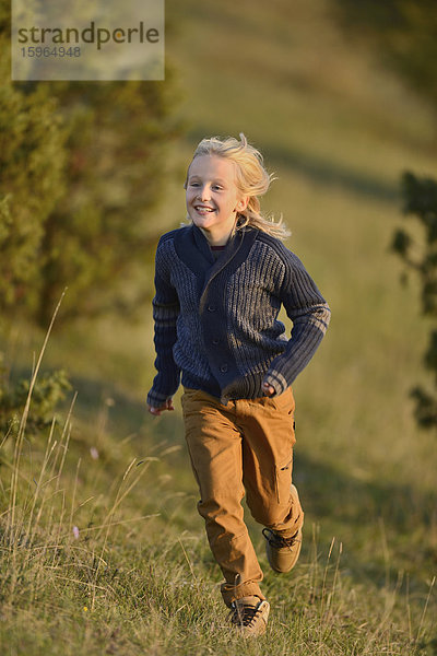 Junge rennt auf einem Hügel