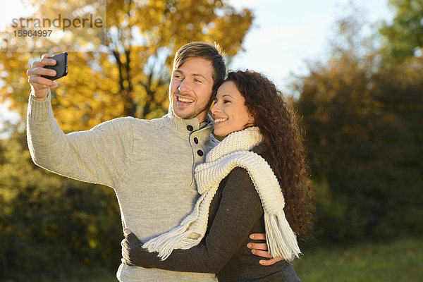 Fröhliches Paar im Herbst macht ein Selbstportrait