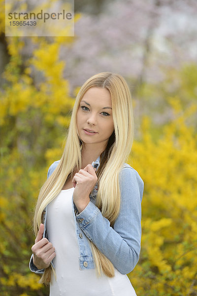 Junge blonde Frau in einem Park im Frühling