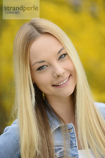 Junge blonde Frau in einem Park im Frühling