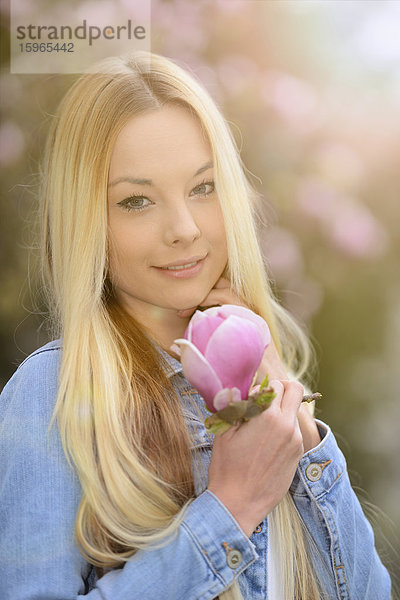 Junge blonde Frau in einem Park im Frühling