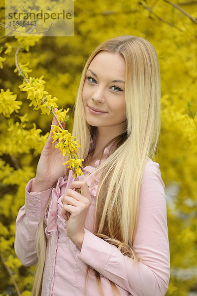 Junge blonde Frau in einem Park im Frühling