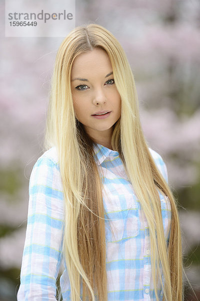 Junge blonde Frau in einem Park im Frühling