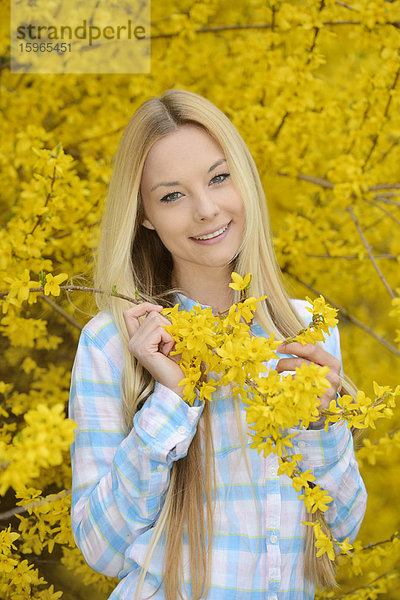 Junge blonde Frau in einem Park im Frühling