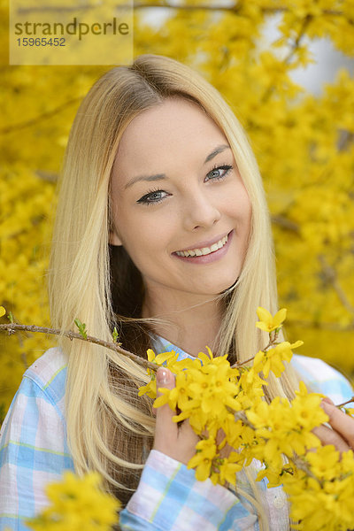 Junge blonde Frau in einem Park im Frühling