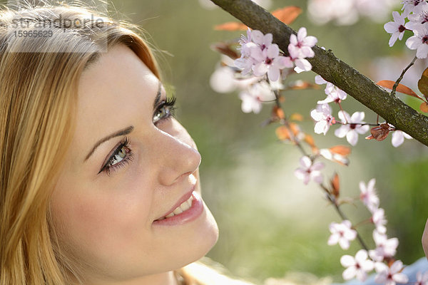 Junge Frau an blühendem Kirschbaum  Portrait