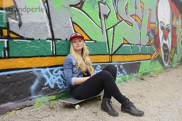 Junge Frau an einer Graffitiwand  Nürnberg  Bayern  Deutschland  Europa