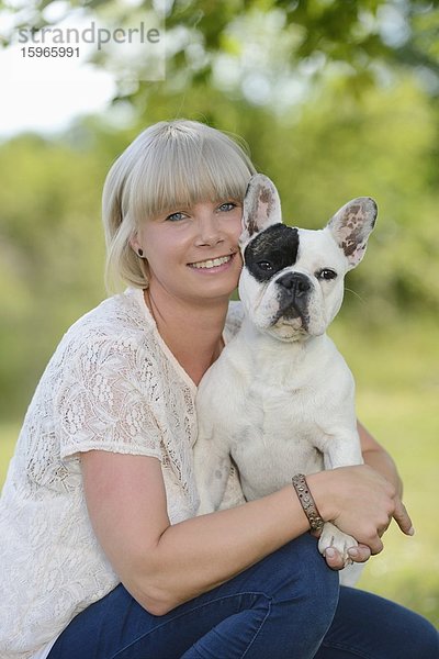 Frau mit einer sieben Monate alten Französischen Bulldogge