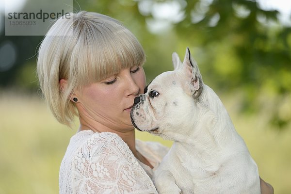 Frau mit einer sieben Monate alten Französischen Bulldogge