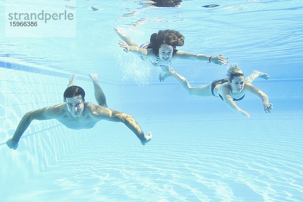 Familie beim Schwimmen unter Wasser in einem Freibad
