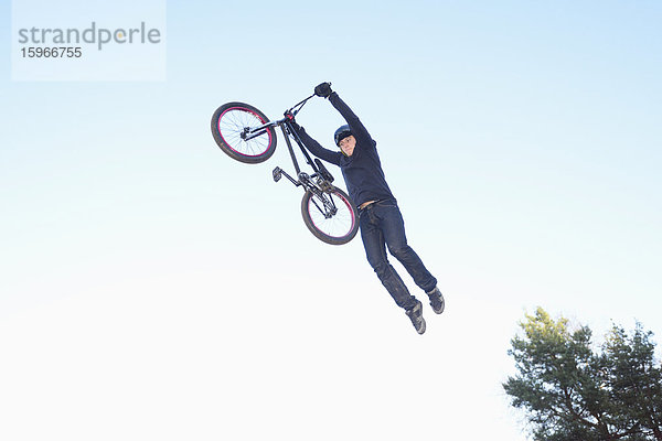 Teenager auf einem BMX-Rad springt in die Luft