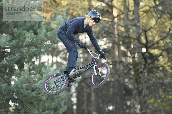 Teenager auf einem BMX-Rad springt in die Luft