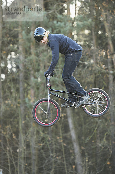 Teenager auf einem BMX-Rad springt in die Luft