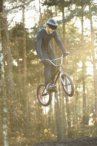 Teenager auf einem BMX-Rad springt in die Luft