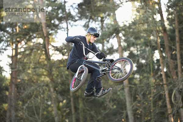 Teenager auf einem BMX-Rad springt in die Luft