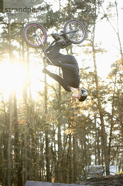 Teenager auf einem BMX-Rad springt in die Luft