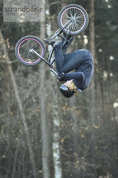 Teenager auf einem BMX-Rad springt in die Luft