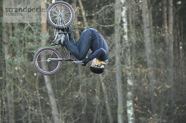 Teenager auf einem BMX-Rad springt in die Luft