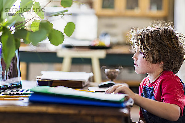 6-jähriger Junge benutzt Laptop für Fernschulung zu Hause