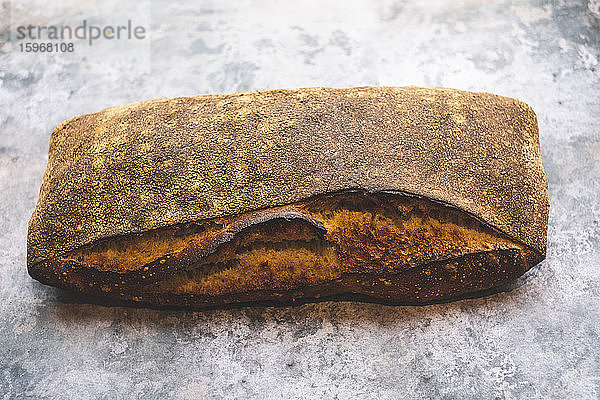 Handwerkliche Bäckerei  die ein spezielles Sauerteigbrot herstellt  einen gebackenen Laib mit fester dunkler Kruste.
