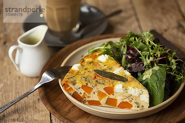 Hochwinkel Nahaufnahme von Frittata mit einem Salat mit Babyblatt in einem Cafe.