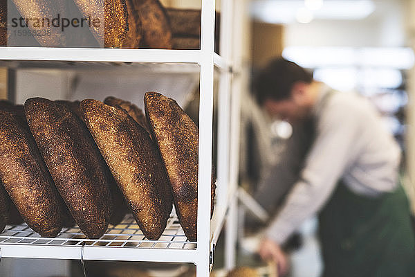 Eine handwerkliche Bäckerei  die spezielles Sauerteigbrot herstellt  Brotkörbe und im Hintergrund ein Bäcker.