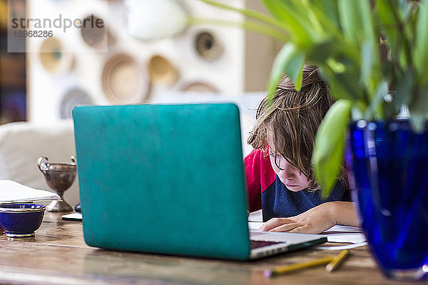 6-jähriger Junge benutzt Laptop für Fernschulung zu Hause