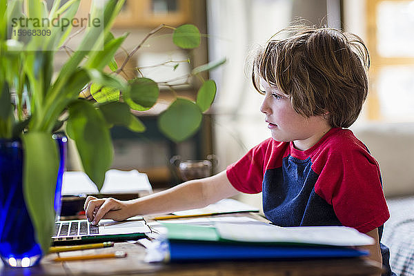 6-jähriger Junge benutzt Laptop für Fernschulung zu Hause