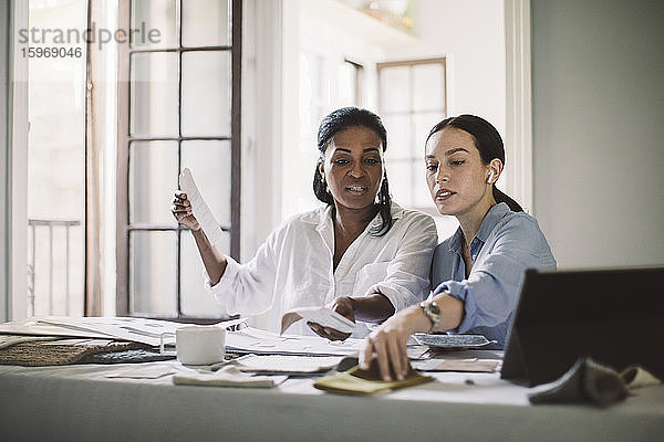 Architektinnen diskutieren bei der Arbeit am Tisch im Home-Office