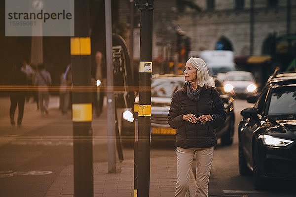 Ältere Frau schaut beim Spaziergang in der Stadt weg