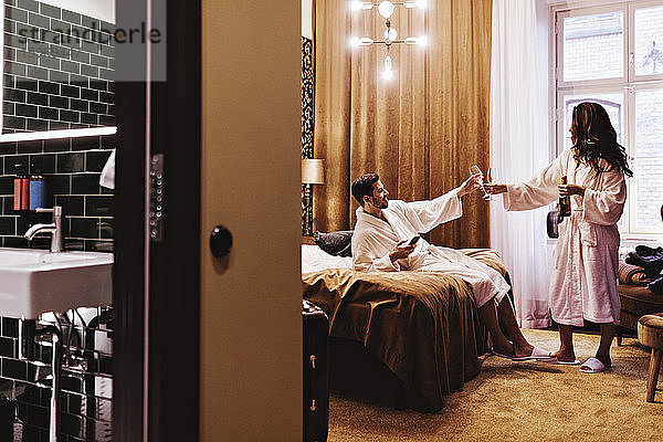 Ehepaar genießt Champagner im Hotelzimmer während des Urlaubs