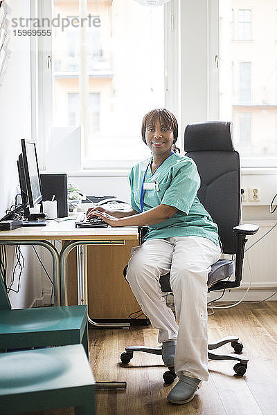 Porträt einer reifen Ärztin  die in der Klinik am Computer arbeitet