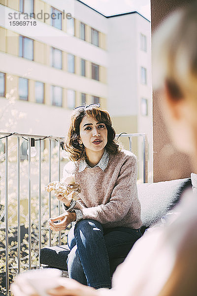 Frau auf dem Balkon im Gespräch mit einer Freundin