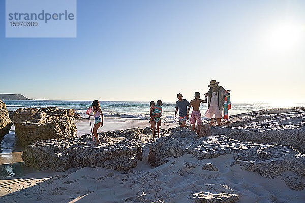 Familie spielt auf Felsen am sonnigen Strand des Ozeans  Kapstadt  Südafrika