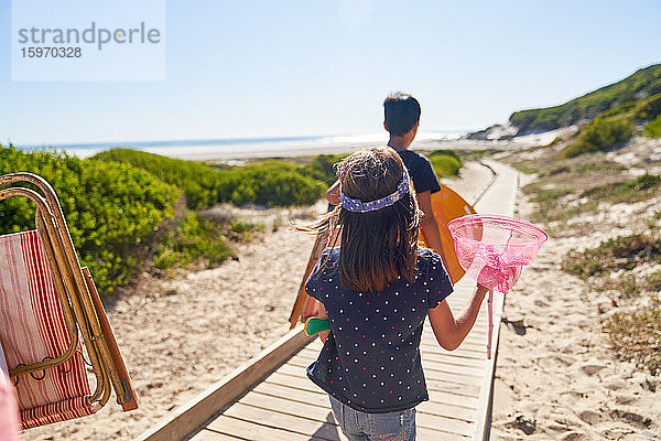 Mädchen trägt Schmetterlingsnetz auf sonniger Strandpromenade