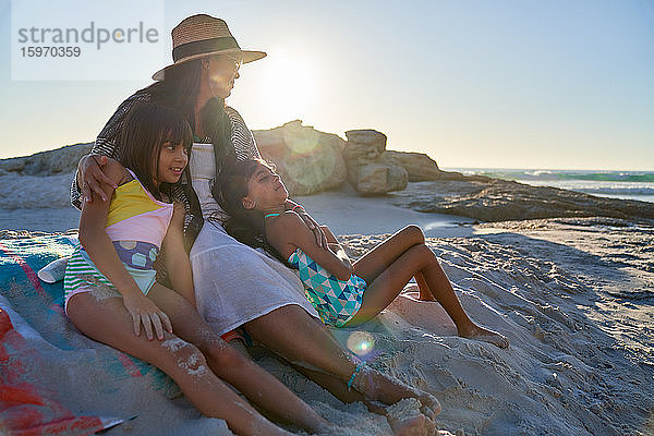 Mutter und Töchter entspannen am sonnigen Strand