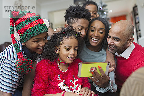 Glückliche Familie nimmt Weihnachts-Selfie mit Smartphone
