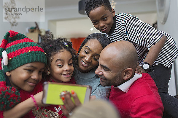 Glückliche Familie nimmt Weihnachts-Selfie mit Smartphone