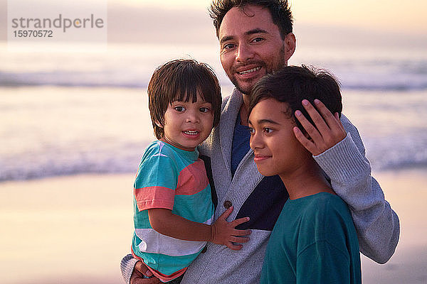 Porträt glücklicher Vater und Söhne am Strand des Ozeans