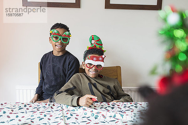Porträt niedlicher Brüder mit festlichen Weihnachtsbrillen