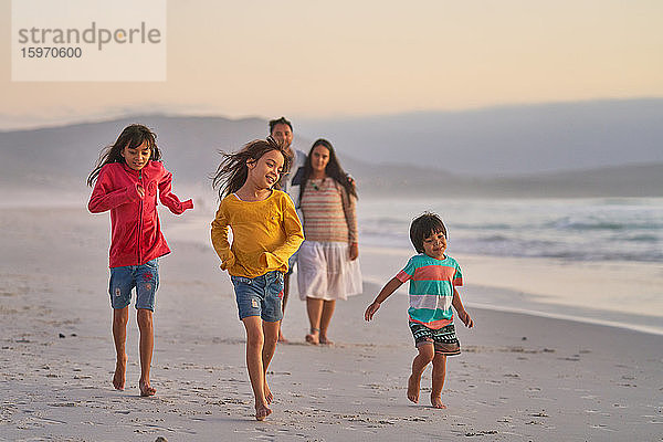 Glückliche Familie läuft am Meeresstrand