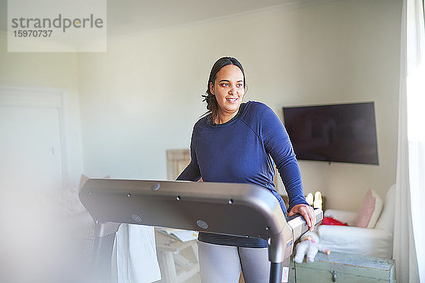 Lächelnde Frau beim Training auf dem Laufband