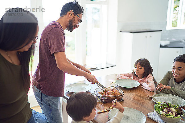 Familie beim Servieren und Essen am Esstisch