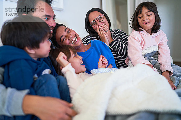 Glückliche Familie lacht auf dem Sofa