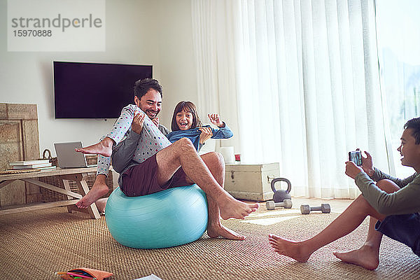 Spielerischer Vater und Kinder beim Sport im Wohnzimmer