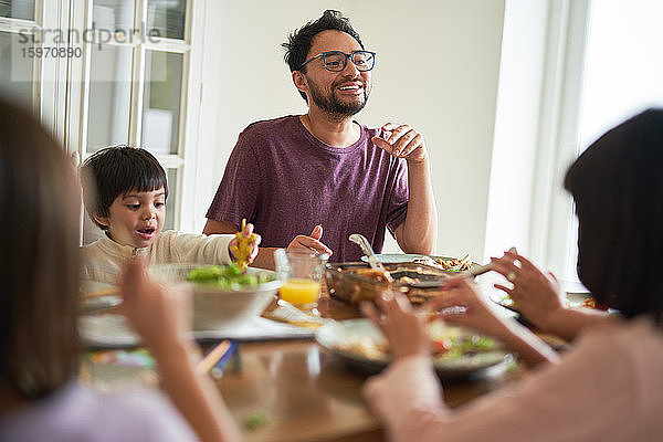 Fröhliche Familie beim Abendessen am Tisch